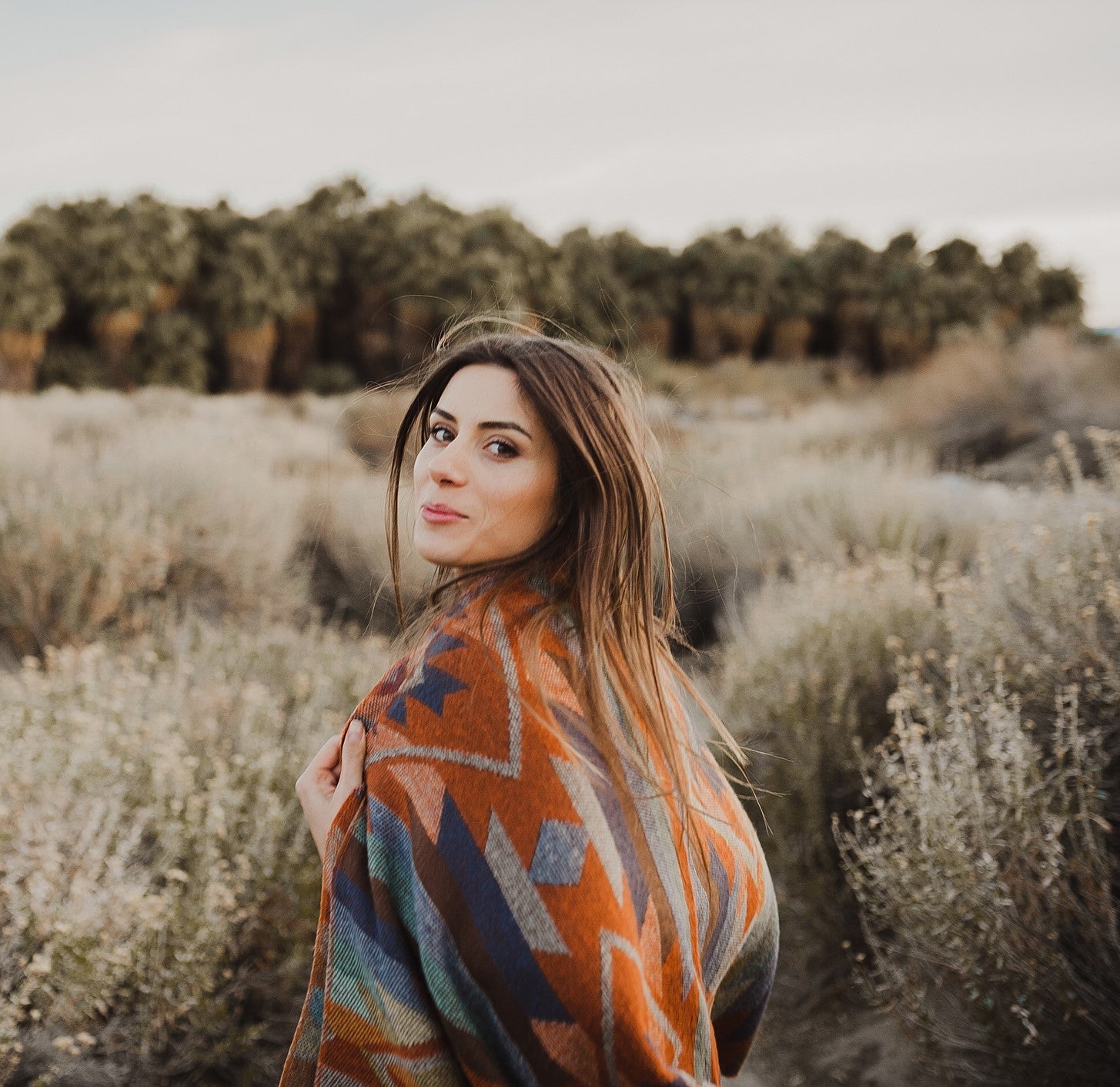 Frau steht selbstbewusst in Wildwiese