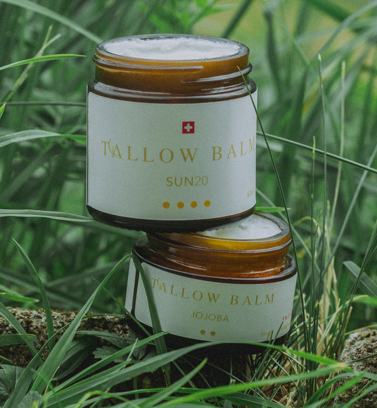 Zwei Swiss Tallow Gläser übereinandergestapelt im grünen Gras