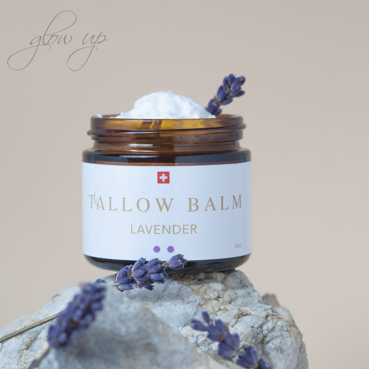 Swiss Tallow Balm Lavender – auf Naturstein platziert, dekoriert mit frischen Lavendelblüten