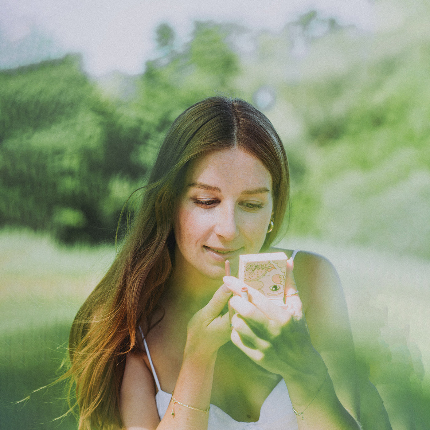 Frau riecht an einem Blatt – Symbol für Naturverbundenheit