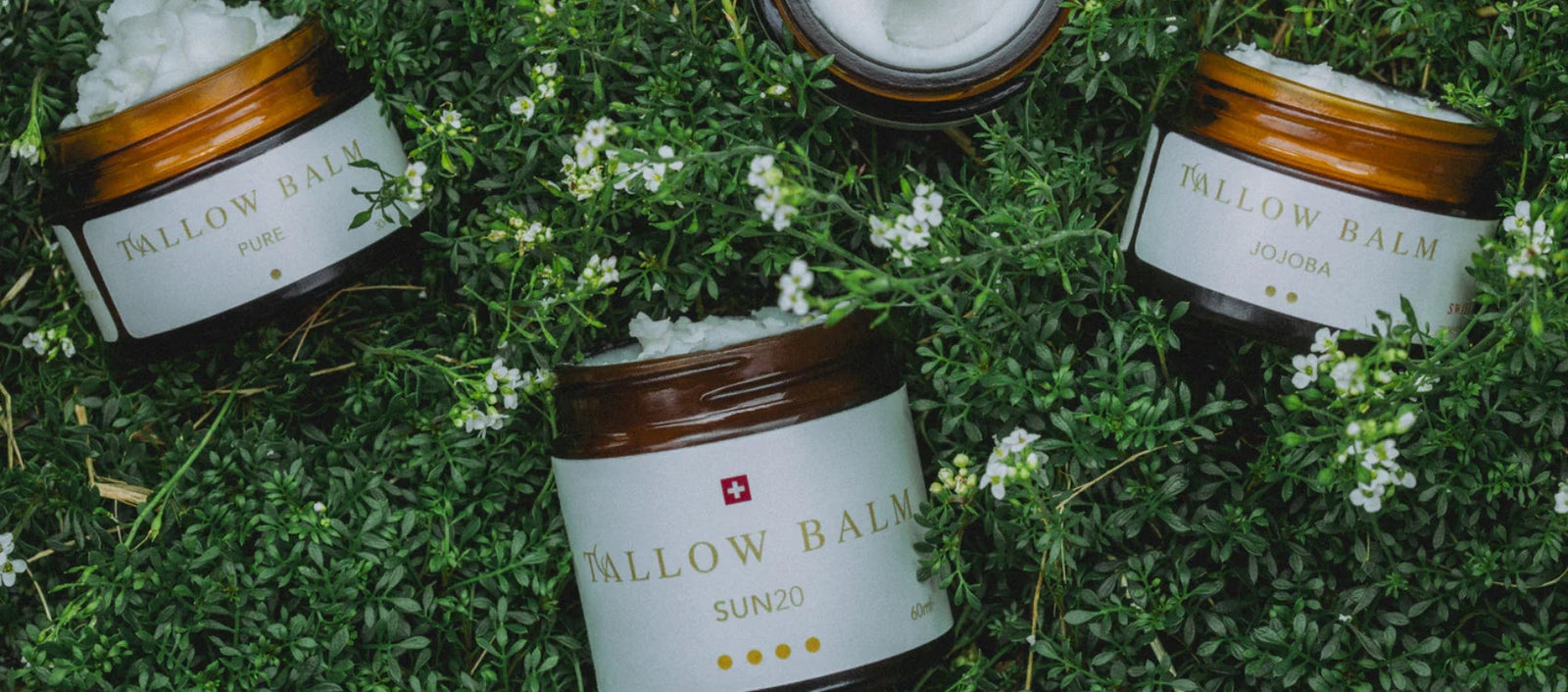 Zwei Swiss Tallow Balms auf Moos – natürliche Produktpräsentation